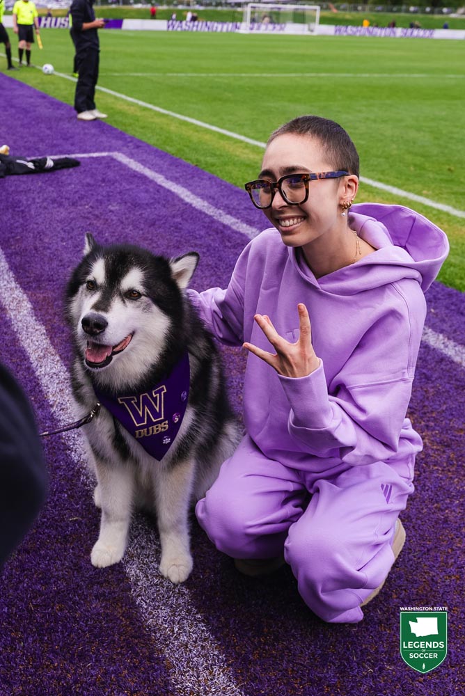 Battling kidney cancer, Mia Hamant poses with the Huskies' mascot Dubs prior to a 2025 home game. (UW Athletics)